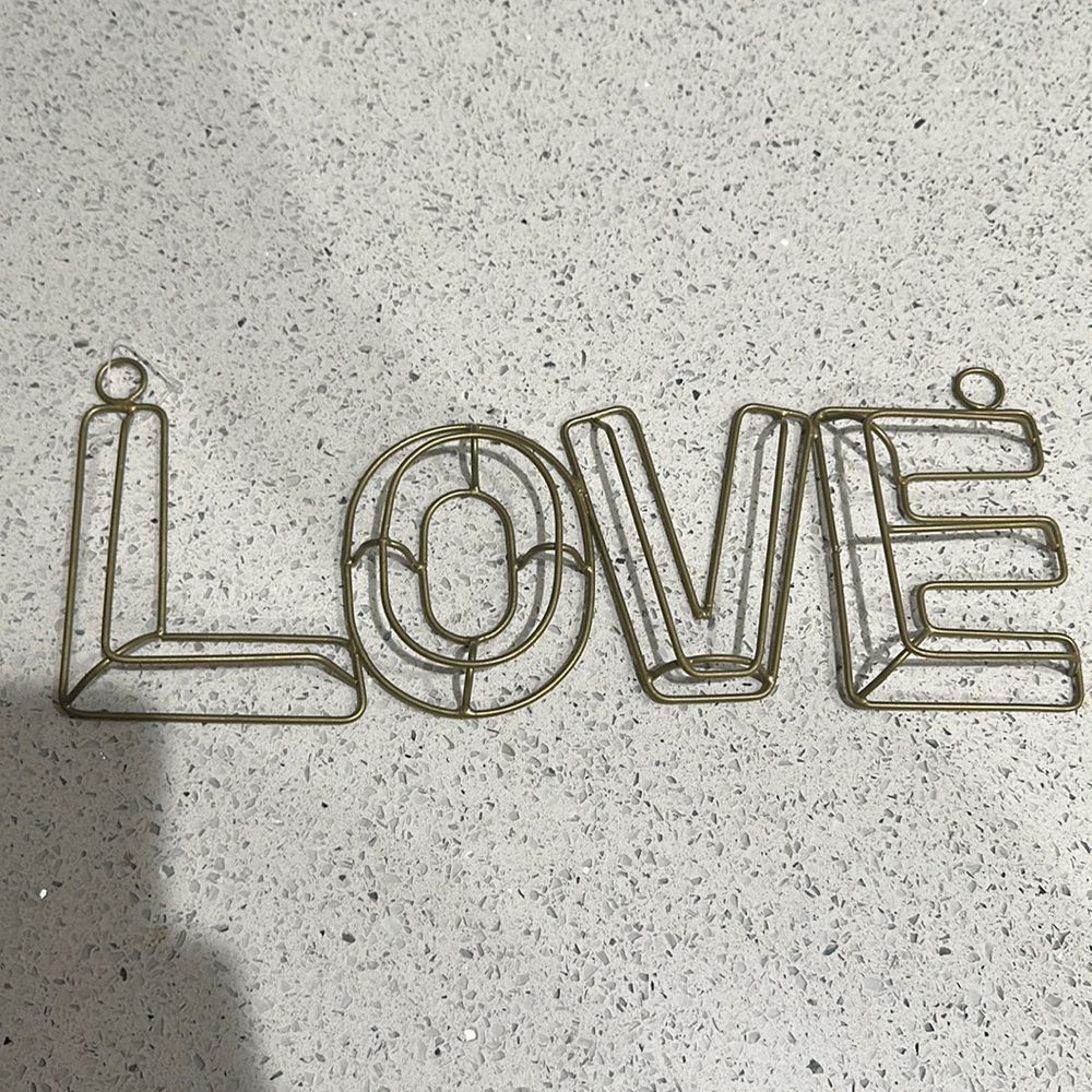 Gold metal 3D sign that says love